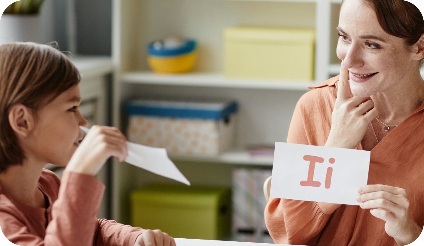 A speech-language pathologist works with her child client using flashcards of vowels. Is speech therapy covered by insurance? In this client's case, it is. The client is diagnosed with a speech delay disorder, therapy for this disorder is covered by the client's insurance policy.