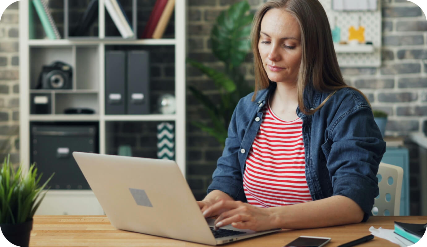 A female therapist works at her laptop and thinks about how to increase rates for clients in private practice