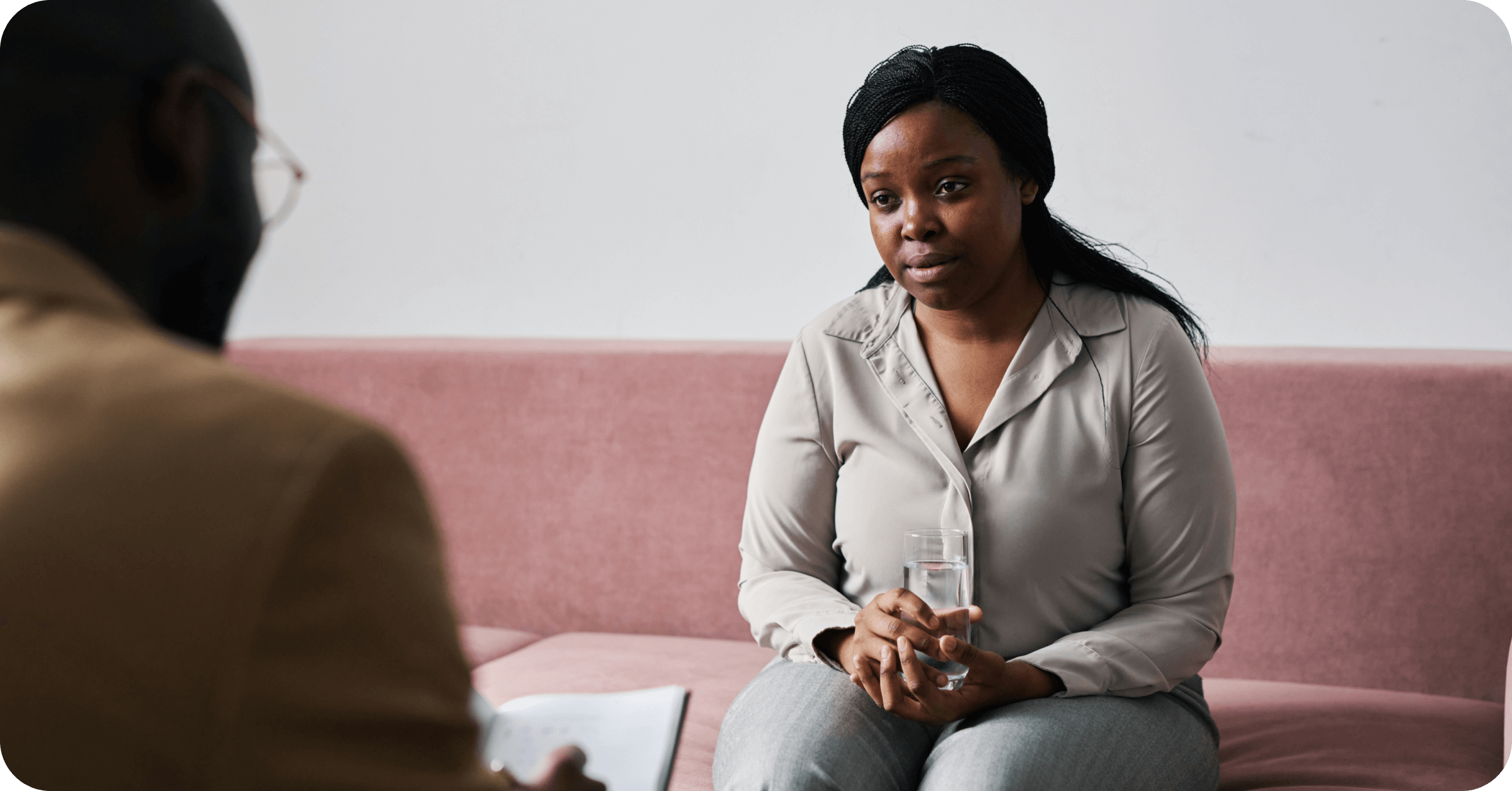 A client faces her therapist as she gets CBT for PTSD treatment. Want to understand more about CBT therapy for PTSD? This article explains CBT for PTSD, including its efficacy, sample treatment plans, and more.