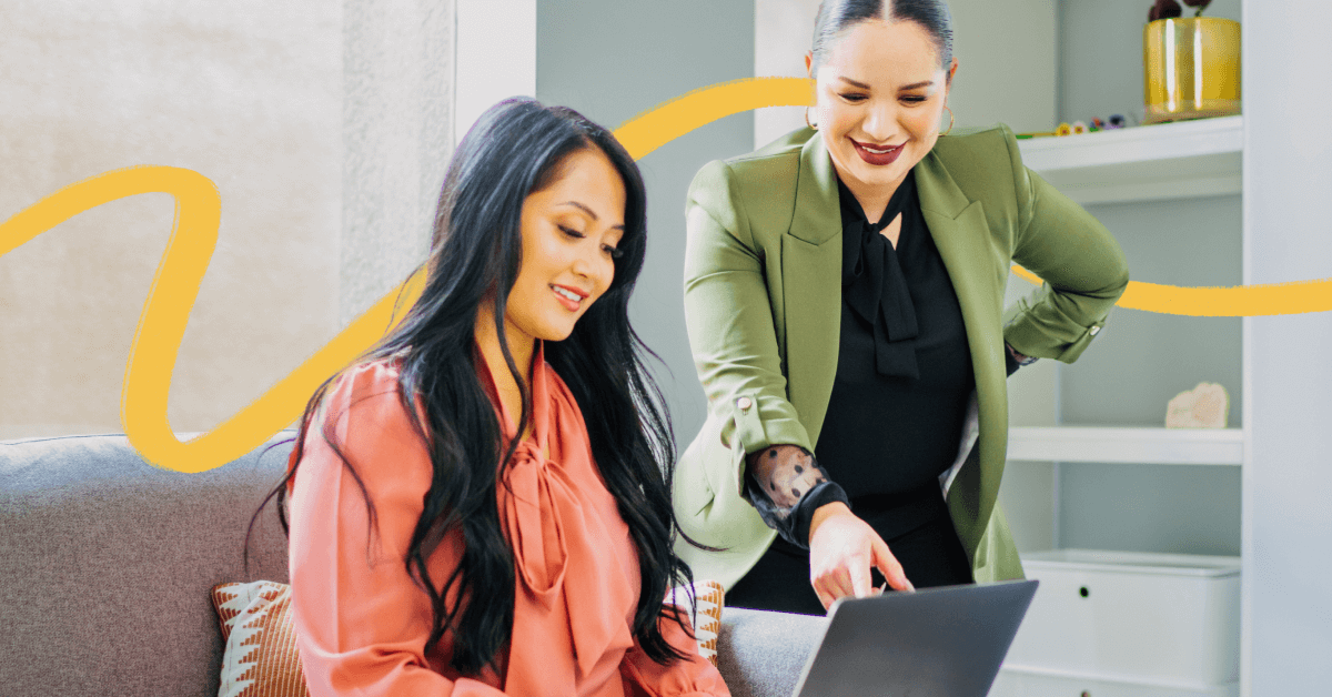 Two therapists who are a mentor and mentee are looking at the computer.