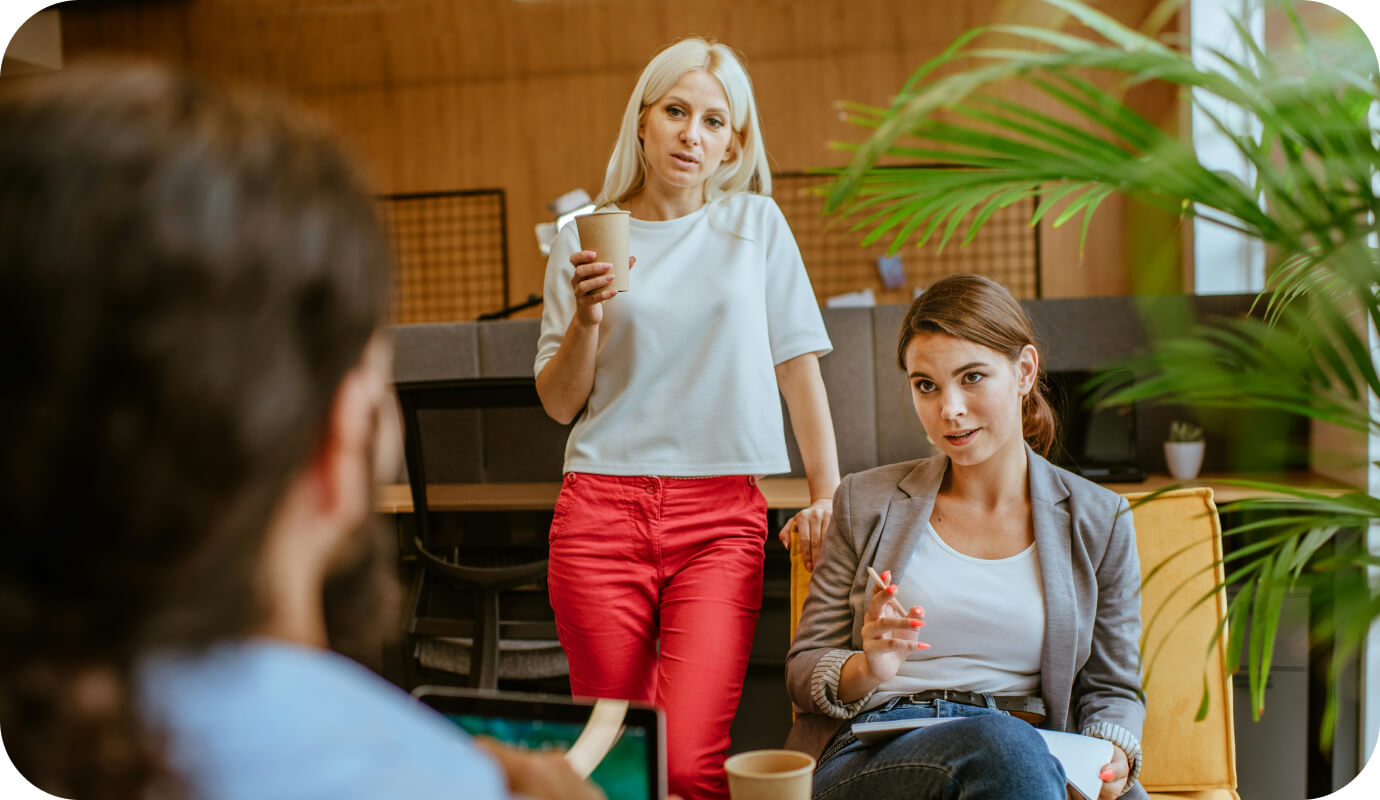 Two female therapists stand in front of their supervisor addressing difficult employees in a group practice