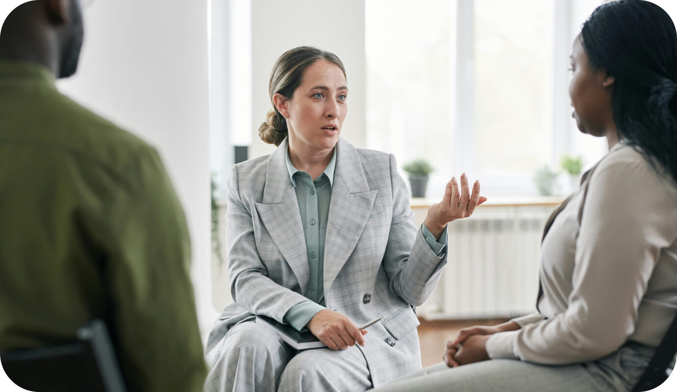 Two female occupational psychologists talk with a businessman to answer the question about what is an occupational psychologist