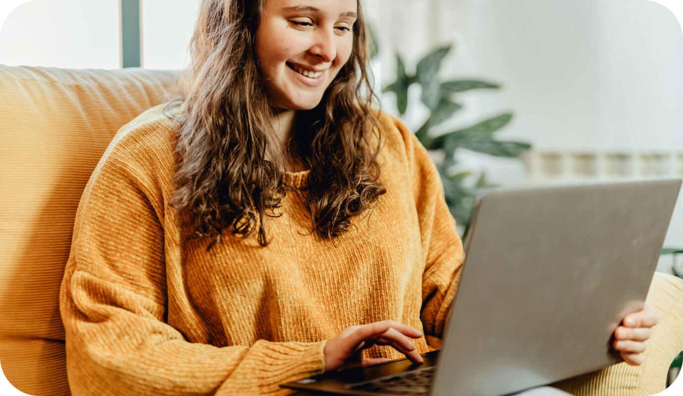 A client sits down on her couch and uses' her therapists EHR scheduling software to book an appointment after-hours.