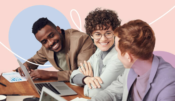 Three people sit in front of computers talking.