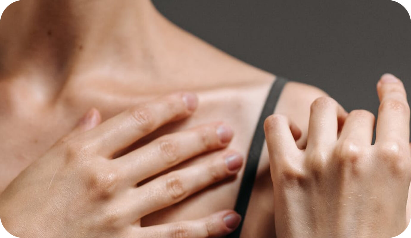 A female therapist rubs essential oils into her collar bone as she follows a therapist self-care checklist.